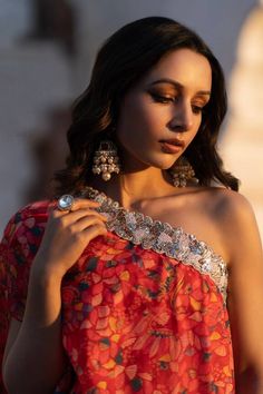 Ruby red padded kurta with leaf print and pearl, metallic dori and green, red bead embroidered neckline. Paired with sharara.
Components: 2
Pattern: Printed, Embroidery
Type Of Work: Leaf, pearl, dori, bead
Neckline: Asymmetric
Sleeve Type: One shoulder sleeve
Fabric: Dola Silk
Color: Red
Other Details: 
Tiered sharara
Occasion: Sangeet - Aza Fashions Fusion Style Pre-draped Saree With Dupatta For Festive Occasions, Festive Fusion Style Pre-draped Saree With Dupatta, Festive Fusion Pre-draped Saree With Dupatta, Multicolor Pre-draped Saree With Gota Work, Fusion Style Pre-draped Saree With Cutdana, Festive Fusion Sharara With Traditional Drape, Fusion Style Party Saree With Dupatta, Red Pre-draped Saree With Mirror Work For Party, Festive Fusion Style Dupatta For Party