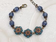 "This is the beautiful blue flower beaded bracelet. It is hand linked together with matte translucent blue Czech glass flower and denim blue crystals. The glass crystals are topped with floral lace filigree bead caps. It is suspended in lobster claw clasp closure along with bronze chain extender. The bracelet length is adjustable from 155mm (6.1 inches) to 205mm (8 inches).  It is a wonderful idea for gift giving and as a little treat for yourself. Your bracelet will presented in a gift box and tied with ribbon. Measurements and details: Length: 155mm (6.1\") - 205mm (8\") Flower: 12mm Crystal: 8mm Chain: Bronze Closure: Bronze lobster claw clasp See more jewelry and vintage treasures here: https://www.etsy.com/shop/thecharmjewelry" Flower Beaded Jewelry, Blue Flower Bracelet, Flower Beaded Bracelet, Czech Beads Jewelry, Vintage Jewelry Ideas, Bracelet Inspiration, Vintage Style Jewellery, Homemade Jewelry, Flower Jewelry