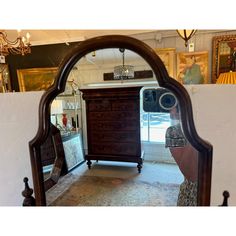 an antique dresser is reflected in a mirror