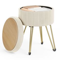 a white stool with gold legs and a magazine holder on the top, next to it