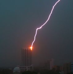 a lightning bolt is seen in the sky over a city