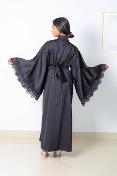 DESIGNER’S NOTE: The Camilla royal black satin kimono robe with its dramatic wide sleeves paired with soft Chantilly lace has a languid figure-skimming silhouette cut to flatter your figure. Wear it as a dressing gown to relax at home. Enjoy elegant loungewear that makes each day feel special Designed to enhance your curves. Comfy chic. FIT: Slightly loose for a relaxed fit. Select your normal size split ATTRIBUTES: Robe Length: 56 inchesModel Stats: 5 ft 6, US 6 wearing a Medium size Color: Bla Feminine Loungewear, Villain Arc, Elegant Loungewear, Natural Dramatic, Black Satin Robe, Satin Dressing Gown, Rose Gown, Lingerie Gown, Long Cocktail Dress