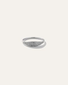 a white gold ring with pave set diamonds on the outside, and a curved band