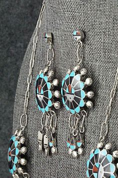 This Zuni Sunface set featuring turquoise, onyx, mother of pearl, coral, opalite and sterling silver inlay necklace, earrings, ring and bracelet was made by Zuni silversmith Abel Soseeah. The set is signed.Necklace: 18"Pendant Length: 2 5/8"Pendant Width: 1 3/4"Earrings:Length: 2 3/4"Width: 1 1/4"Bracelet:Size: 5 5/8" (will fit up to a 6 5/8" wrist)Gap: 1"Width: 1 5/8"Ring:Size 7.5Width: 1 1/4Length: 1 1/4Free shipping on all orders! We ship with USPS and always include tracking. All orders ship Traditional Multi-stone Collectible Jewelry, Southwestern Multi-stone Pendant Jewelry, Traditional Jewelry With Natural Stones For Collectors, Southwestern Silver Jewelry With Inlay, Traditional Black Jewelry With Polished Finish, Turquoise Round Jewelry With Sterling Silver Clasp, Artisan Turquoise Jewelry With Polished Finish, Artisan Jewelry With Sterling Silver Clasp, Turquoise Jewelry With Sterling Silver Clasp