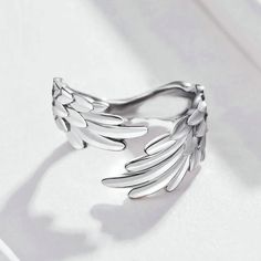 Our Wings Ring is designed for those who seek elegance and individuality.Inspired by the majestic wings of birds, this timeless accessory embodies a sense of empowerment and strength, making it the perfect statement piece for both men and women. Its sleek and minimalist design ensures versatility, allowing you to effortlessly pair it with any outfit, from casual to formal. Its wraparound design gracefully curves around your finger, providing a comfortable fit while exuding a sense of effortless Angel Wing Ring, Silver Angel Wings, Feather Ring, Silver Wings, Feather Jewelry, Finger Rings, 925 Jewelry, Pandora Jewelry, Sterling Silver Charm