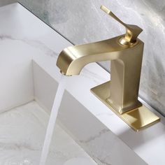 a gold faucet running water from a sink