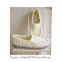 a pair of crocheted slippers sitting on top of a white table next to a wall