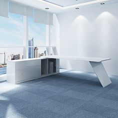 an empty room with a white desk and blue carpeted flooring in front of large windows