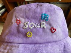 Hand embroidered and tie-dyed bucket hat! One size fits most. 58cm. MADE TO ORDER: Hat will not look EXACTLY like the image as each hat is made after purchase. Summer Bucket Hat With Embroidered Logo, Casual Purple Cotton Bucket Hat, Casual Purple Bucket Hat For Spring, Casual Embroidered Bucket Hat, Casual Purple Bucket Hat With Curved Brim, Casual Embroidered Adjustable Bucket Hat, Spring Wide Brim Bucket Hat With Embroidered Logo, Casual Purple Festival Hat, Casual Purple Hat For Festivals