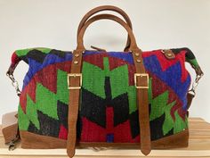 Our Handmade Bohemian Kilim Leather Travel Bag is a top pick for eco-conscious shoppers and sustainable lifestyle advocates. The roomy interior and durable construction make it a reliable choice for weekend getaways and outdoor adventures, while the multicolor woven design and leather accents make it a stylish accessory for fashion-conscious nomads and rustic explorers.Looking for a versatile statement piece? Our Handmade Vintage Kilim Leather Multicolor Bag is the perfect pick for creative indi Kilim Bag, Carpet Bag, Leather Travel Bag, Vintage Turkish Kilim Rug, Handmade Kilim Rugs, Leather Accents, Antique Inspiration, Woven Design, Sustainable Lifestyle