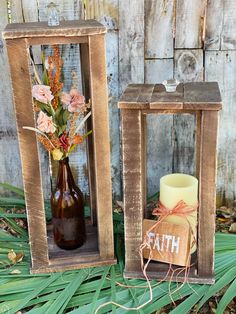 two wooden crates with flowers in them sitting on the ground next to a candle holder