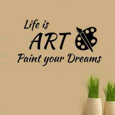 the words life is art paint your dreams in black on a wall next to two vases with green grass