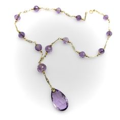 This is part of Chairish’s Fine Jewelry assortment.  The hand faceted Rose de France amethyst beads in this 14k gold Edwardian necklace have stunning facets that catch the light like prisms. The center stone is a flattened teardrop-shaped briolette with elongated triangular facets. The round beads along the chain descend in size; each are hand faceted and subtly different in shape, like tulip bulbs. The stones are the pale purple that Rose de France is known for—a lighter colored amethyst with softer tones that are romantic and feminine. The amethyst beads are sandwiched between 14k gold wirework, held together by traditional French fancy links—narrow almond shaped links with intricate filigree work. Circa 1915, the lace like quality of this necklace is very elegant but also suggests a mov Fine Jewelry Briolette Faceted Necklace, Fine Jewelry Faceted Briolette Necklaces, Elegant Purple Faceted Beads Gemstones, Faceted Amethyst Briolette Necklace, Elegant Faceted Purple Crystal Necklace, Elegant Purple Necklace With Faceted Beads, Formal Faceted Amethyst Necklace, Faceted Lavender Briolette Jewelry, Elegant Purple Faceted Crystal Necklace