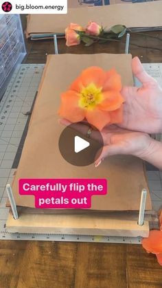 a person is making a flower out of paper