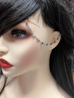 a female mannequin with black hair and silver jewelry on it's head