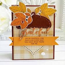 a close up of a card on a table with flowers in the background and an orange ribbon around it