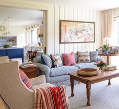 a living room filled with furniture and a painting on the wall above it's fireplace