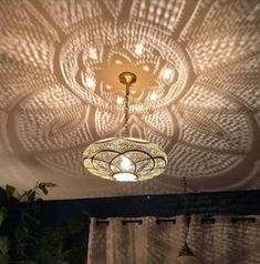 a chandelier hanging from the ceiling in a room with curtains and drapes