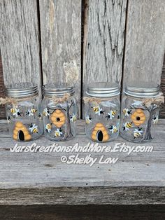 three mason jars with bees and daisies painted on them