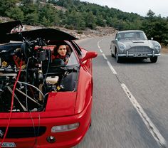 two cars driving down the road with an engine in the back