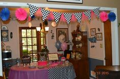 a table with pink, blue and white decorations on it in a room decorated for a baby's first birthday