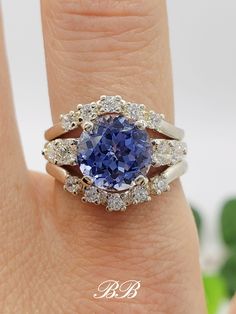 a woman's hand with a tan diamond and blue sapphire ring on her finger