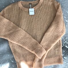 a brown sweater is sitting on the ground