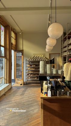 the inside of a bakery with lots of food on shelves and pans hanging from the ceiling