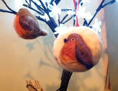 two felt birds are hanging from a tree