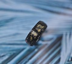 a close up of a ring on top of blue and white striped material with gold zodiac symbols