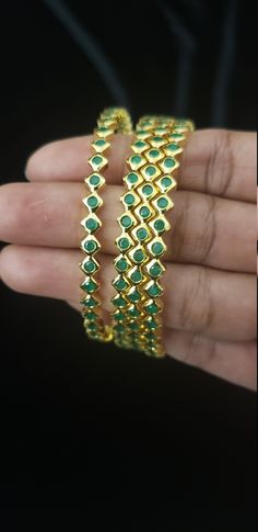 "* Handcrafted Gold Plated 4 Bangle Set. Sold as a set. * Bangles with high quality Semi precious emerald stones. * High Quality 22K Gold Plated. Bangles Sizes : 2.4 inches= ( 2.25\" diameter of the inner circle) ; 2.6 inches = ( 2.42\" diameter of the inner circle); 2.8inches = (2.54\" diameter of the inner circle) The gorgeous gold-plated bangles set best exemplifies the careful craftsmanship done on it -- specially picked for you by Nemali Jewelry. It has a special tone of elegance attached t Green Stone Work Bangle Jewelry, Green Stone Work Temple Jewelry Bracelets, Green Temple Jewelry Bangle With Stone Work, Green Temple Jewelry Bracelets With Stone Work, Gold Stackable Emerald Jewelry, Green Bangle With Stone Setting, Green Bangle For Formal Festivals, Green Bangle For Formal Events And Festivals, Green Stone Work Bracelet