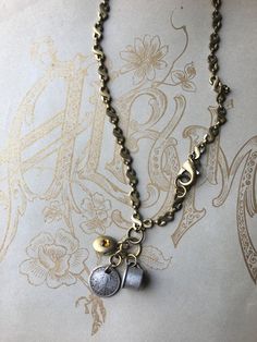 "Vintage Charm Necklace from my Love Letter Series (#2) representing special meanings, feelings and events from time passed.  This one features a vintage Sterling Silver baby cup engraved \"baby\", a 10 centavo silver coin from the Filipinas United States of America, which were circulated from 1937 to 1945, and a mini vintage opening brass locket adorned with a topaz colored crystal. 20 inch vintage antiqued chain with oversize antiqued brass lobster claw designed to be worn front or side as par Sterling Silver Charm Necklace, Vintage Sterling Silver Charms, Charms Necklace, Special Necklace, Sterling Silver Charms, Topaz Color, Evil Eye Necklace, Leaf Pendant, Love Letter