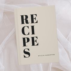 a book that is laying on top of a white sheet with the word recipe printed on it