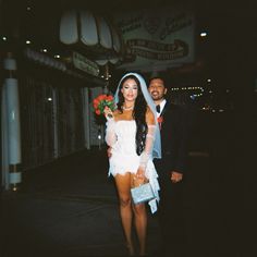 a man standing next to a woman in a white dress