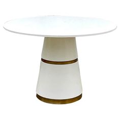 a white table with gold trim around the edge and an oval shaped center piece on top