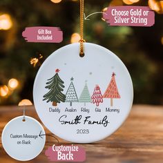 personalized christmas ornament hanging from a tree with ornaments around it on a table