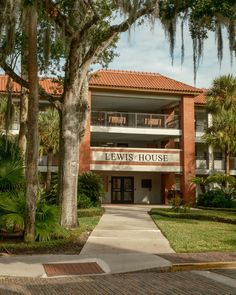 A view of Lewis House with brick architecture, surrounded by lush greenery in St. Augustine, Florida. Rail Transport, Brick Architecture, St Augustine Florida, Hotel Motel, White Car, City Car, Lush Greenery, St Augustine, Image House