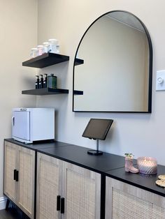 a room with a mirror, shelf and other items on the wall next to it