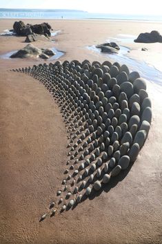 a sculpture made out of rocks on the beach