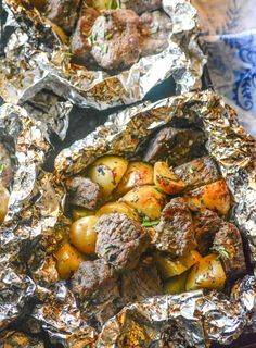 two foil packets filled with meat and potatoes