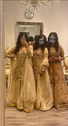 three women are standing in front of a mirror