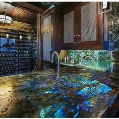 a kitchen counter top that has wine bottles on it and is surrounded by wood cabinets