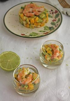 shrimp and mango salad served in small glass bowls with lime wedges on the side