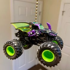 a toy monster truck hanging from a chain