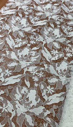 an image of a table cloth with white flowers on brown paper and lace around the edges