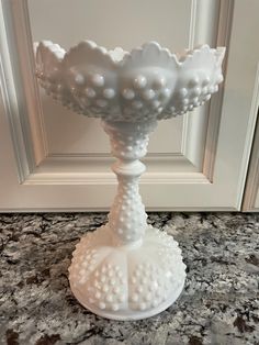 a white vase sitting on top of a counter