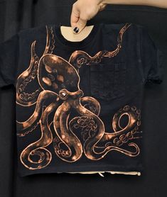 an octopus t - shirt is being held by someone