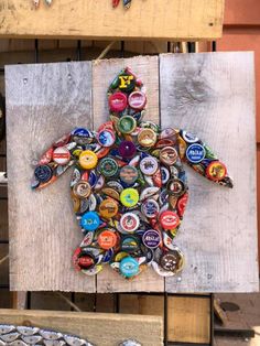 a man made out of beer bottle caps sitting on top of a wooden pallet