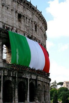 an italian flag is being displayed on the side of a building in rome, italy