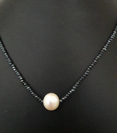 elegant necklace with black spinell and freshwaterpearl, diameter 12 mm  While saltwaterpearls naturally tend to grow round, freshwaterpearls need to be cultivated in this form.  The prize increases with the size, and with 12mm this pearl is already a small treasure.  The length is variable between 44,5 and 47 cm, the clasp is a silver carbine, but it`s possible to change it to a 333 or 585 gold carbine.  If other lengths are needed, feel free to ask. Elegant Rondelle Pearl Necklace With Faceted Beads, Elegant Faceted Rondelle Pearl Necklace, Elegant Pearl Necklace With Faceted Rondelle Beads, Elegant Black Pearl Necklace With Charm, Black Beaded Pearl Necklaces With Pearl Pendant, Black Beaded Necklace With Pearl Pendant, Black Beaded Necklaces With Pearl Pendant, Black Beaded Necklace With Pearl Charm As Gift, Classic Black Pearl Chain Necklace